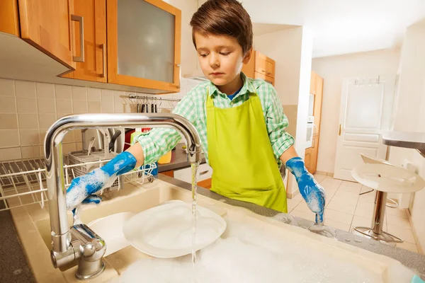Menino lavar pratos com esponja — Fotografia de Stock