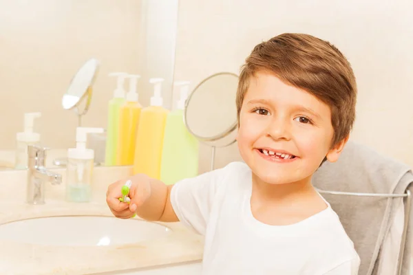 Мальчик в зеркале во время чистки зубов — стоковое фото