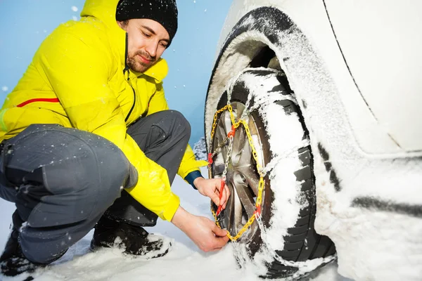 Șofer care instalează lanțuri de zăpadă pentru anvelope — Fotografie, imagine de stoc