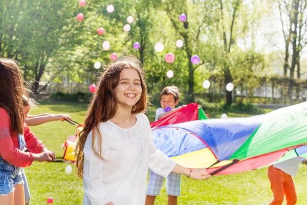Kids with rainbow parachute — Stock Photo, Image