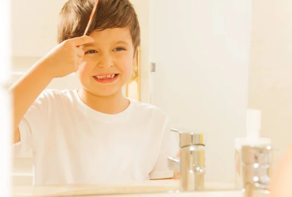 Glücklicher Junge beim Kämmen der Haare — Stockfoto