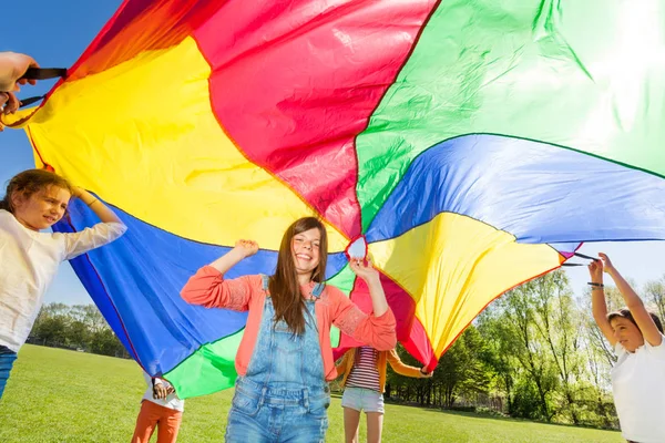 Crianças com pára-quedas arco-íris — Fotografia de Stock