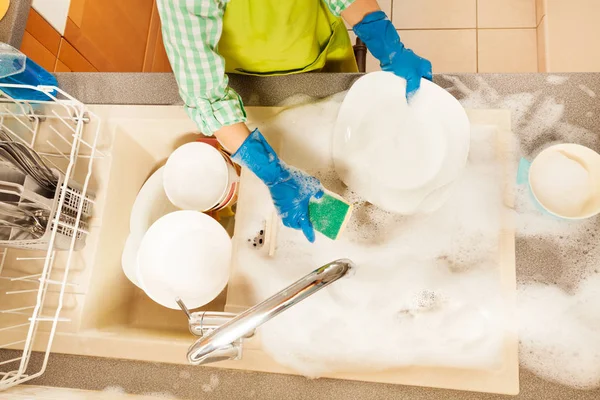 Menino lavar pratos com esponja — Fotografia de Stock