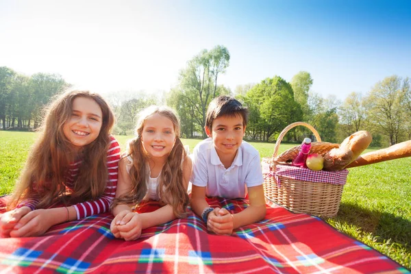 Freunde legen sich auf Picknickdecke — Stockfoto