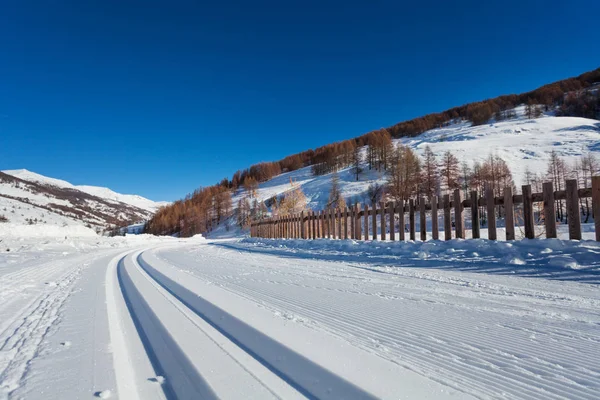 Snowcapped road to alpine resort — Stock Photo, Image