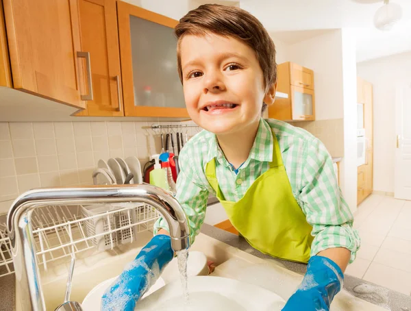 Мальчик мыть посуду — стоковое фото