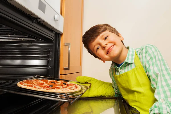 Pojke bakade hemmagjord pizza — Stockfoto