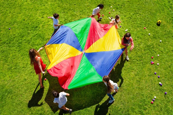 Crianças felizes com paraquedas coloridos — Fotografia de Stock