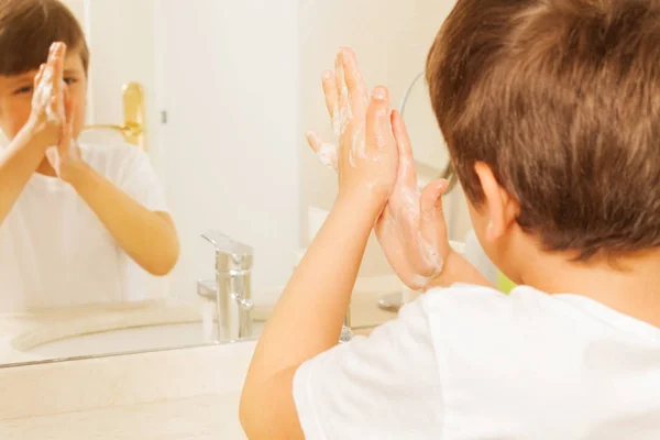 Garçon se laver les mains avec du savon — Photo