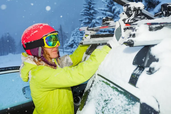 Vrouwelijke bevestiging Ski's aan dakrails — Stockfoto