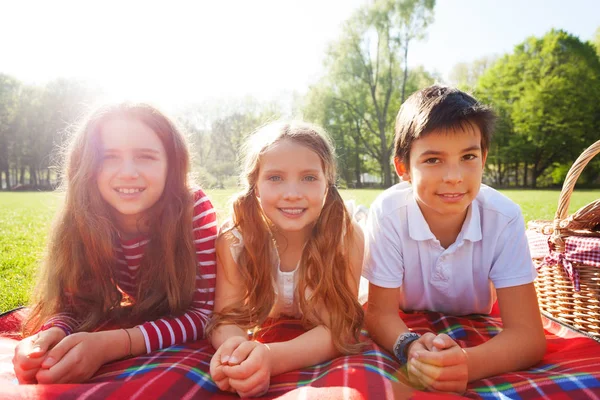 Freunde legen sich auf Picknickdecke — Stockfoto