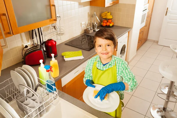 笑みを浮かべて少年食器を洗う — ストック写真