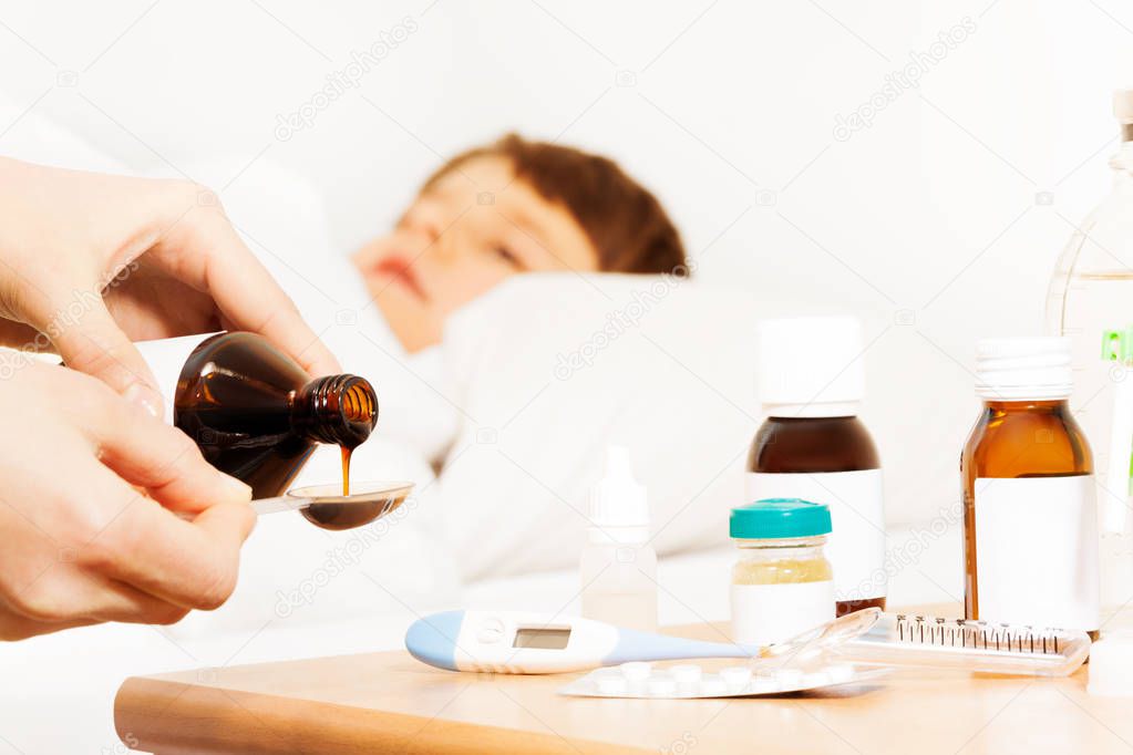 Woman pouring antipyretic syrup