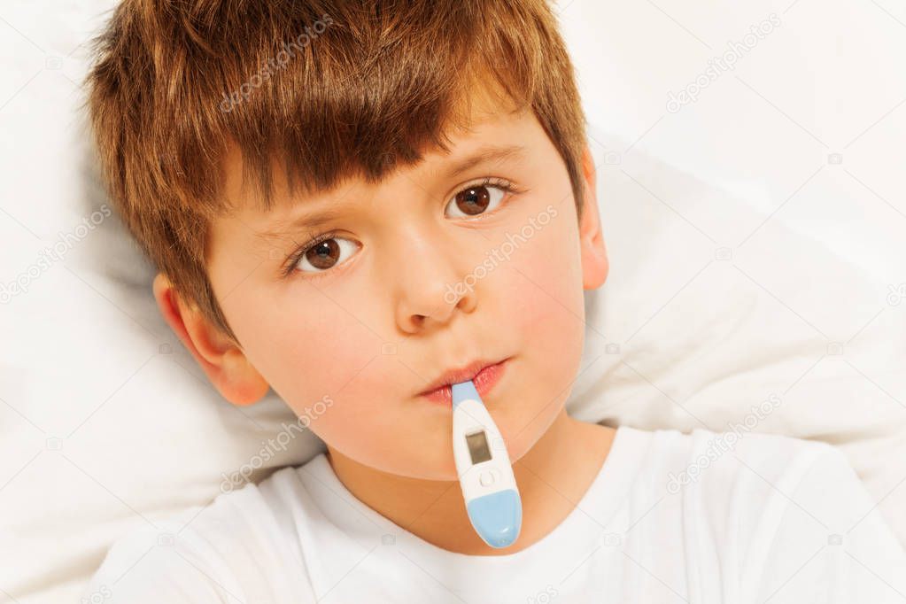 sick boy with electronic thermometer
