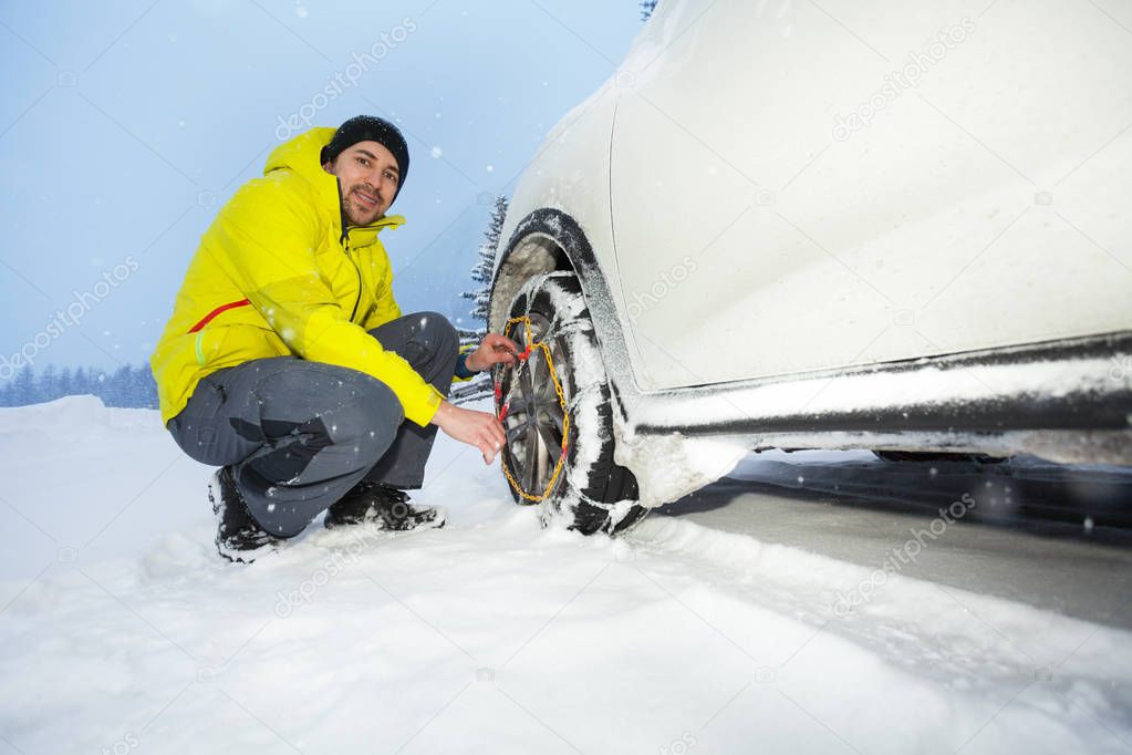 driver installing tyre snow chains