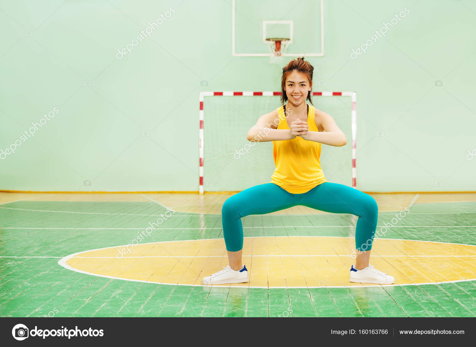 Girl standing in sumo squat position Stock Photo serrnovik 160163766