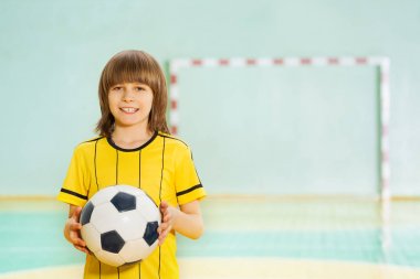 Futbol topu tutan çocuk gülümseyen