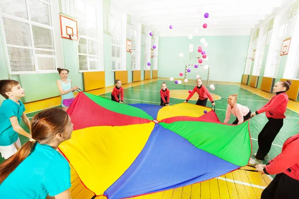Meninos e meninas jogando jogos de paraquedas — Fotografia de Stock