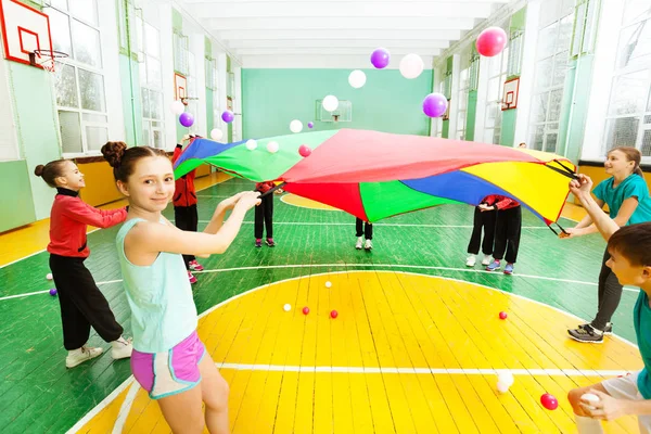 Niños y niñas jugando juegos de paracaídas —  Fotos de Stock