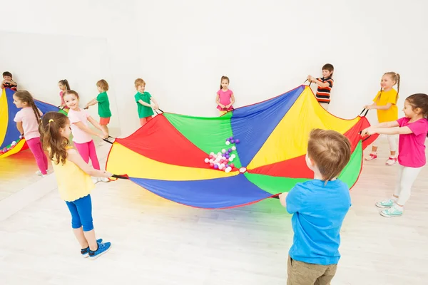 Niñas y niños con paracaídas — Foto de Stock