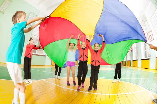 Niños y niñas jugando juegos de paracaídas —  Fotos de Stock