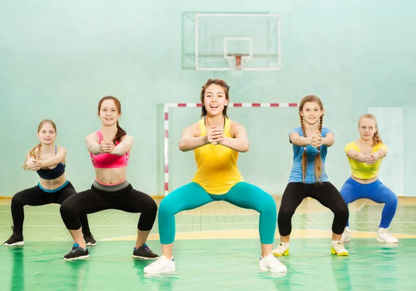 Meninas desportivas fazendo agachamentos — Fotografia de Stock