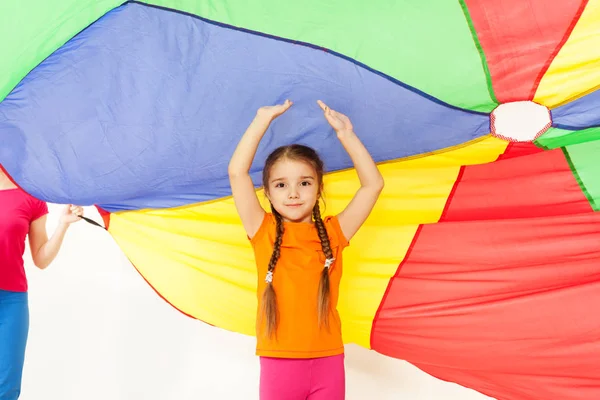 Девушка под цветным парашютом — стоковое фото