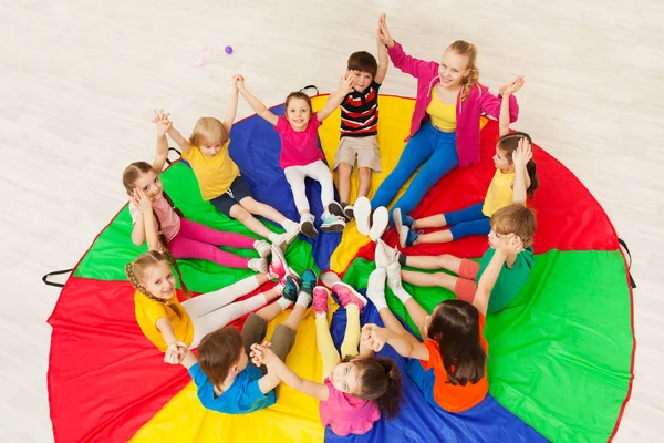 Meisjes en jongens met parachute — Stockfoto