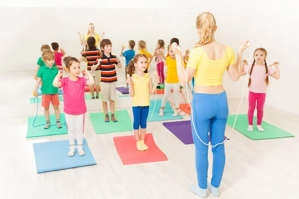 Bambini con allenatore utilizzando corda di salto — Foto Stock