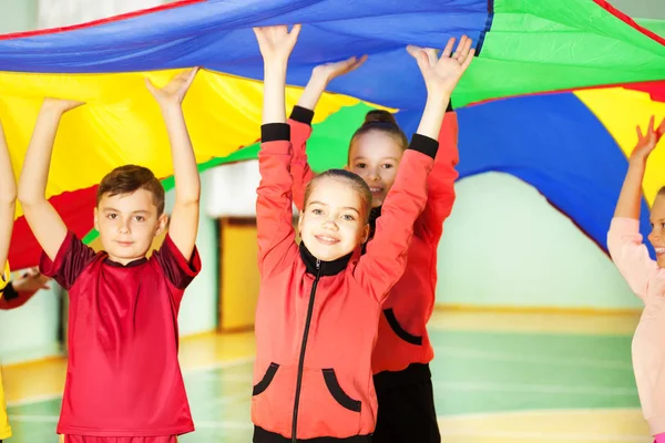 Мальчик и девочки играют в парашютные игры — стоковое фото