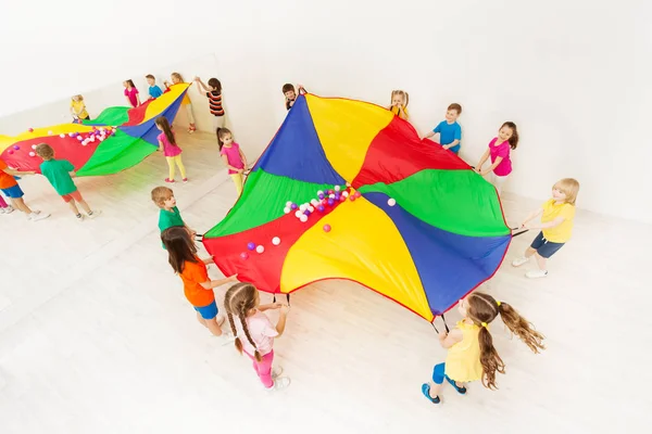 Mädchen und Jungen mit Fallschirm — Stockfoto