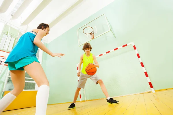 Menino e menina jogando basquete — Fotografia de Stock