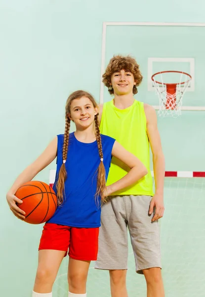 Chico y chica posando con pelota — Foto de Stock