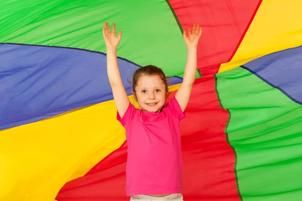 Fille sautant sous parachute coloré — Photo