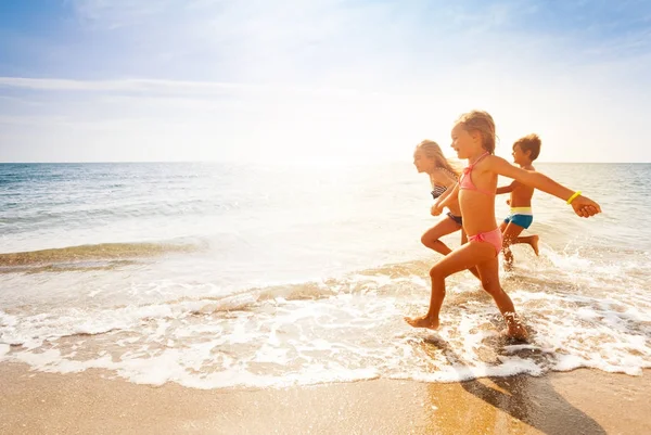 Dzieci biegają na piaszczystej plaży — Zdjęcie stockowe