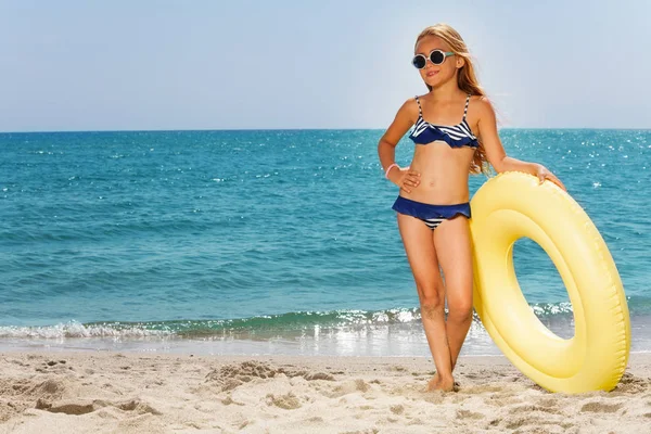 Menina segurando anel de borracha na praia — Fotografia de Stock