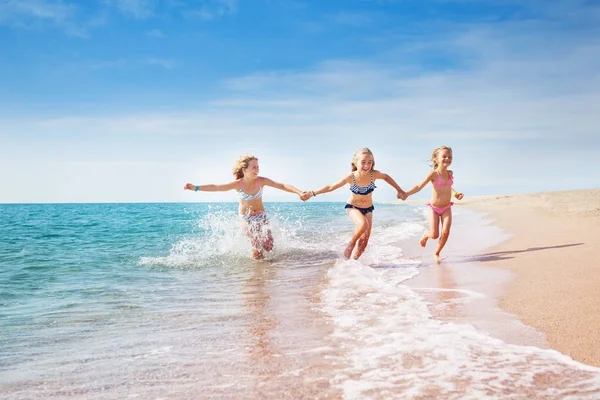 Tjejer kör på sandstrand — Stockfoto