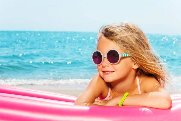 Chica tomando el sol contra el mar azul — Foto de Stock