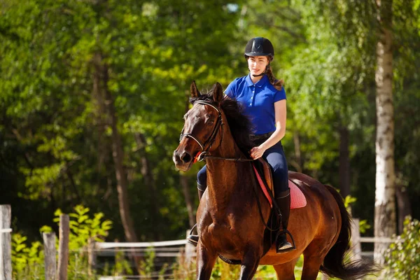 Жокей девочка тренирует лошадь на ипподроме летом — стоковое фото