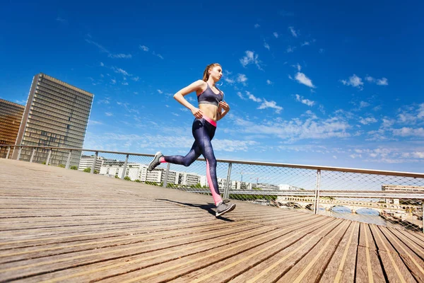 运动员的侧面图在城市对蓝天的奔跑 — 图库照片