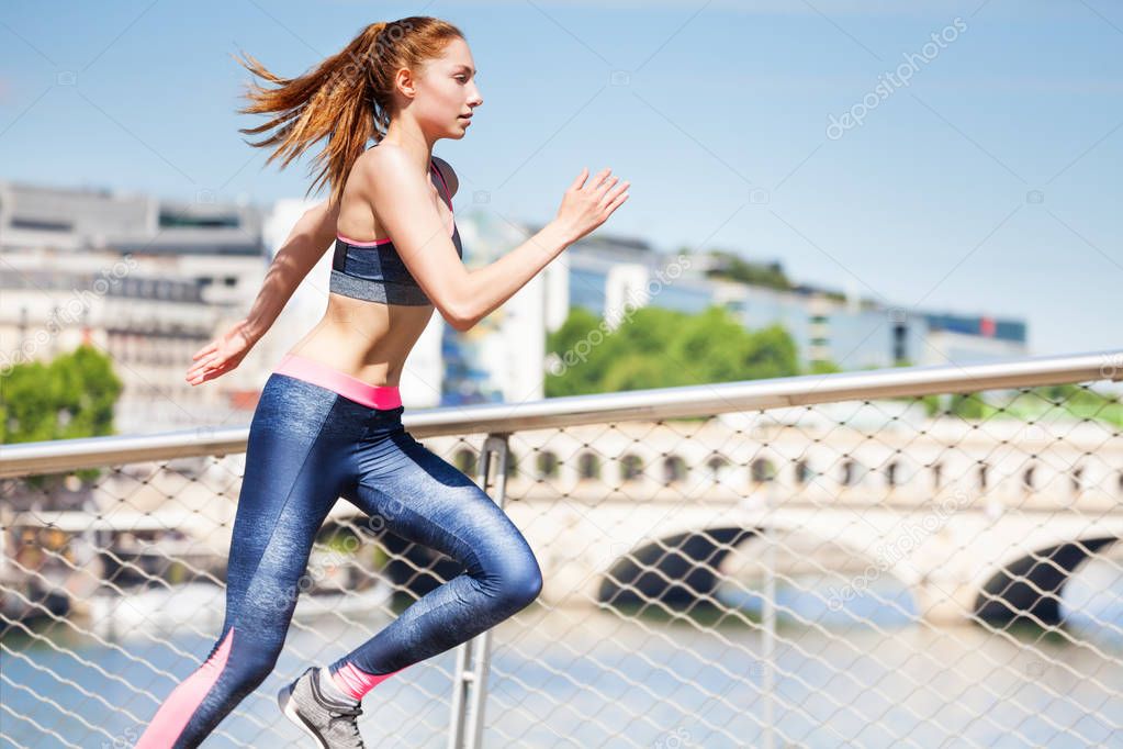 Active young woman sprinting across the city 