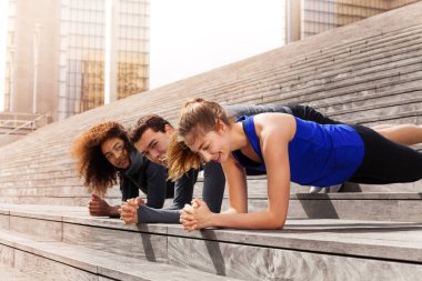 Çok ırklı sporcular dirsek tahta, birlikte bir doğrultusunda ayakta açık havada güneşli gün holding portresi