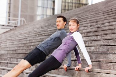 Geriye doğru tahta pozisyonlarını, birlikte açık havada egzersiz şehir merdivenlerde sportif genç Çift