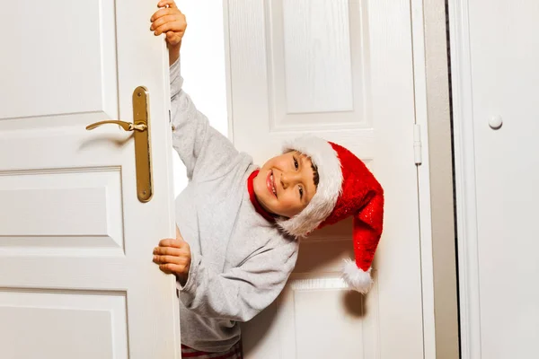 Маленький Мальчик Держит Дверь Глядя Висит Улыбаясь Шляпе Санта Клауса — стоковое фото