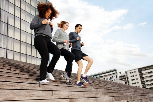 Drei Aktive Junge Leute Sportkleidung Laufen Gemeinsam Die Treppe Hinunter — Stockfoto