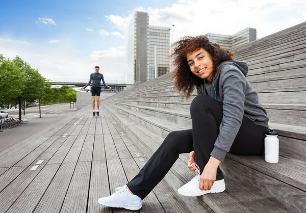 Mujer Africana Sonriente Ropa Deportiva Atando Sus Zapatos Sentada Aire —  Fotos de Stock