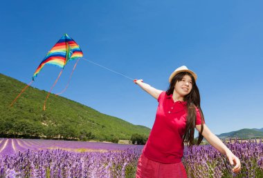 Lavanta alanındaki renkli uçurtma uçan mutlu genç kız