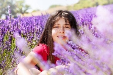 Lavanta alanında yaz aylarında oturan romantik genç kız portresi