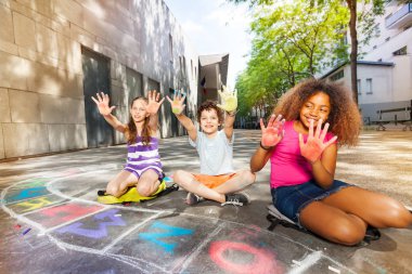 Grup çocuk kameraya bakarak tebeşir renk avuç içi göster