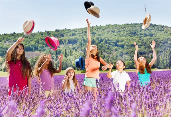 Fröhliche Altersgemischte Kinder Stehen Lavendelfeld Und Werfen Sommertag Hüte Hoch — Stockfoto